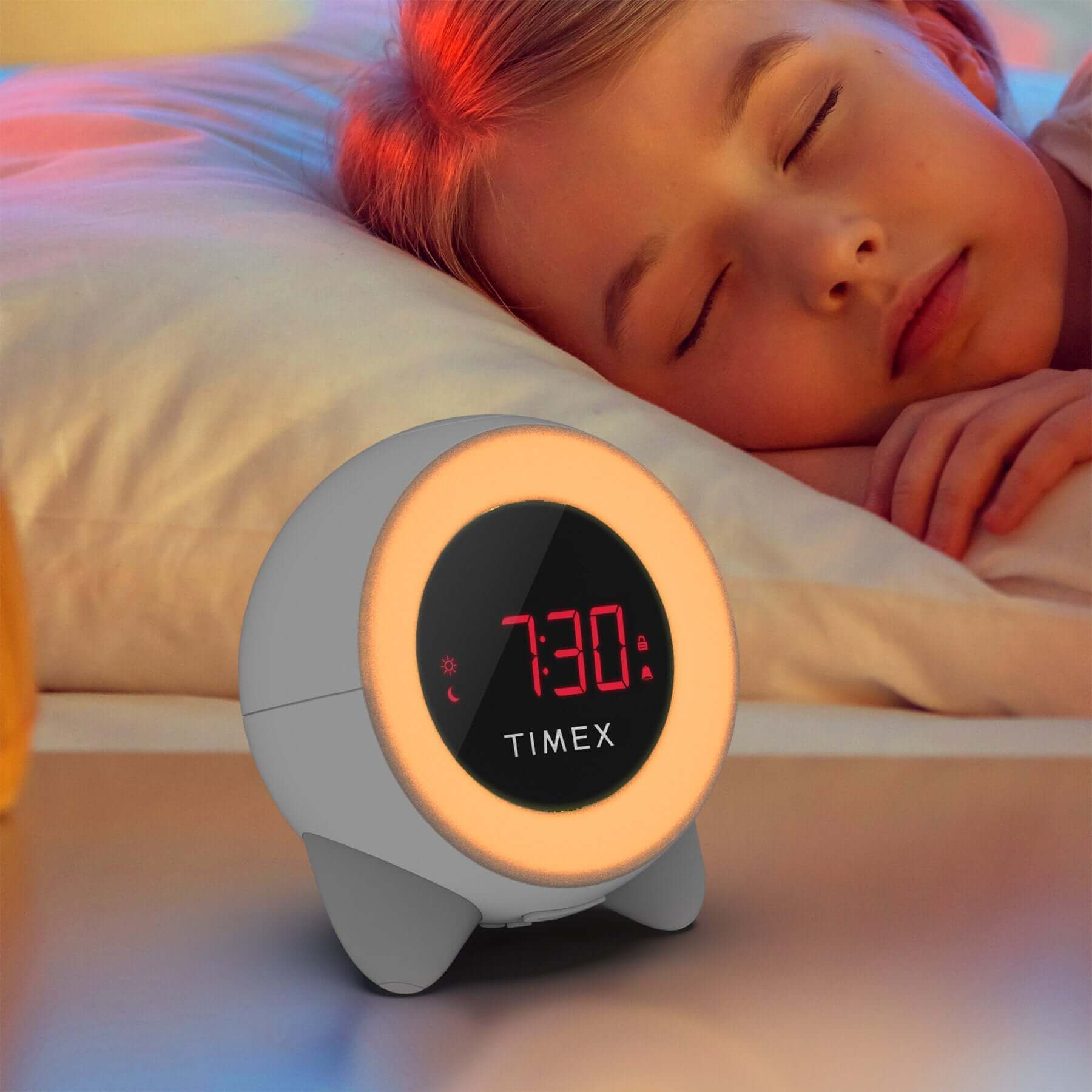 Timex Sleep Training Alarm Clock TK321 glowing red to signal sleep time beside a sleeping child.