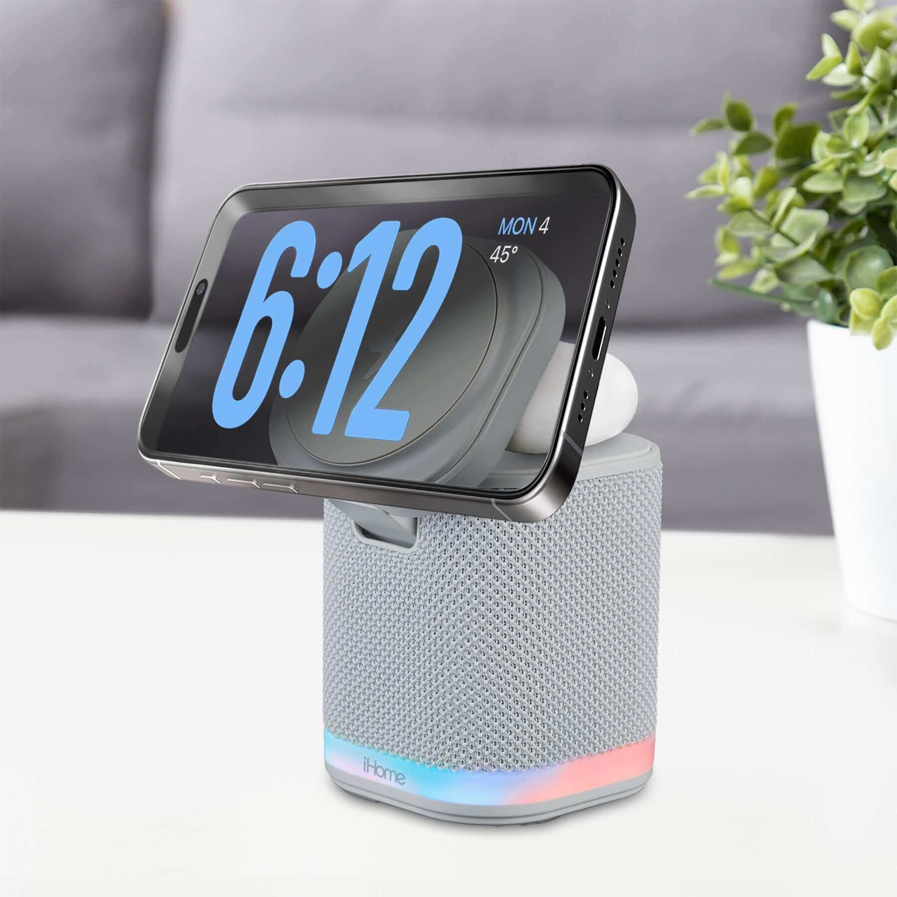 Bluetooth speaker with wireless charger and color changing night light in light gray with a smartphone displayed on the MagSafe pad.