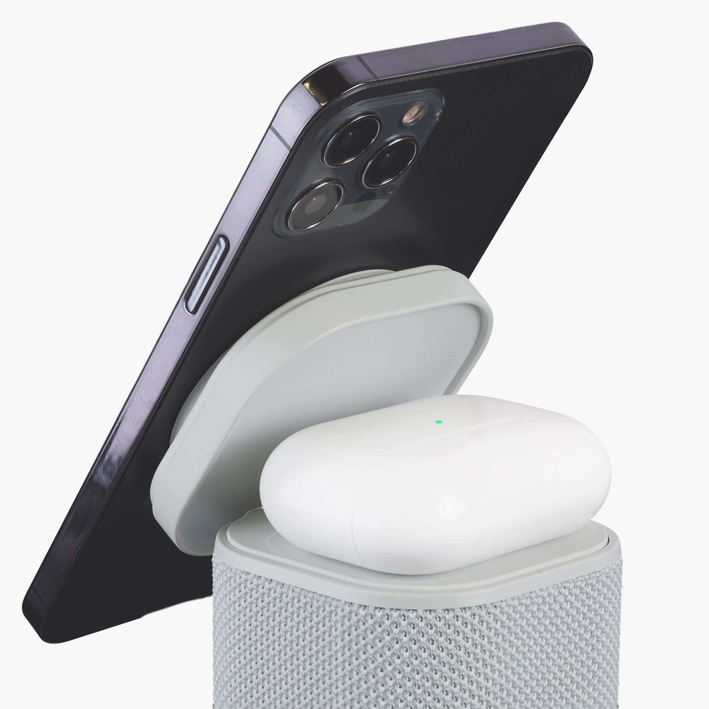 Light gray Bluetooth speaker with wireless charger charging a smartphone and AirPods, color changing night light feature displayed.